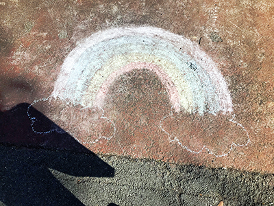Rainbow drawn on the ground in chalk.