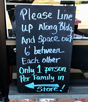 Sign: Please line up along bldg and space out 6' between each other. Only 1 person per family in store.