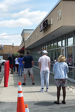 Line of customers 6 feet apart waiting to go into a store