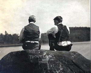 Admiring the scenery: photo of two men, seated on a rock, looking out over Trout Lake.