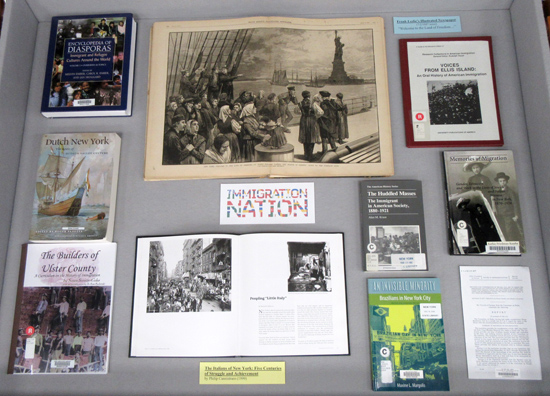 Display Case 1: Books on immigration and an illustration from the 7/2/1887 issue of Frank Leslie's Illustrated Newspaper
