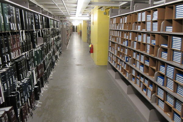 Talking Book and Braille Library stacks, with braille books shelved on the left and audio cartridges on the right