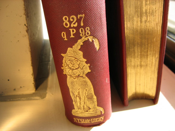 Two bound volumes of Punch magazine showing a gold dog on the spine and gold foreedges