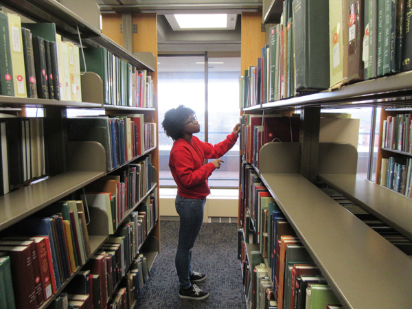 A staff member retrieving material from the stacks