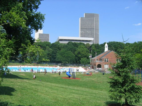 The Cultural Education Center in summer, with the park and pool in the foreground.