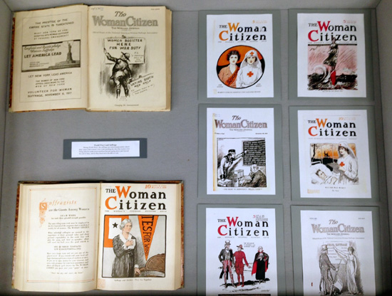 left display case, with magazine covers linking women's suffrage to women's WWI efforts.