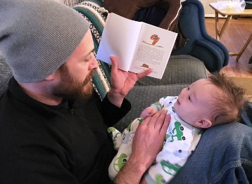 father reading to infant boy