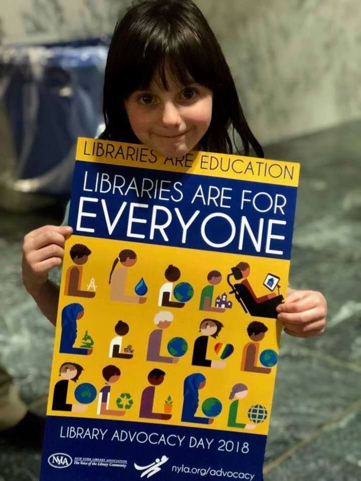 girl holding a Libraries Are For Everyone poster